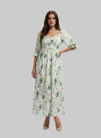 Woman modeling ArokaLife floral print maxi dress with puff sleeves on grey background