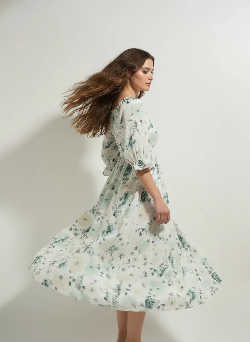 Woman in flowy floral midi dress posing against plain background, Aroka Life fashion New Zealand
