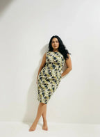 Woman modeling a sleeveless, patterned midi dress against a plain white wall, ArokaLife fashion.