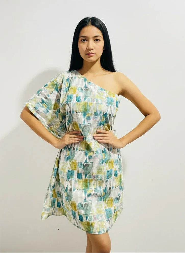 Woman modeling a modern abstract print one-shoulder dress from Aroka Life