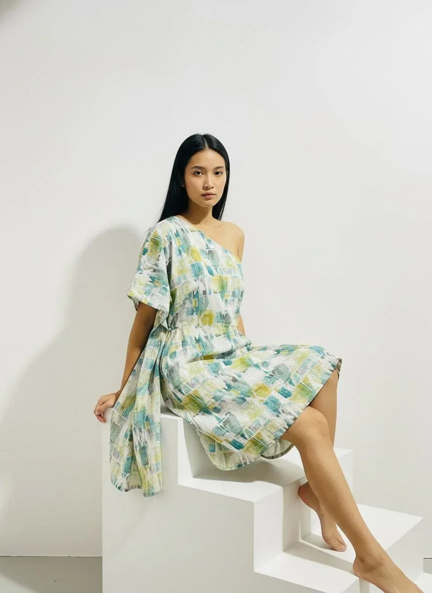 Woman in modern one-shoulder patterned dress posing for ArokaLife fashion collection